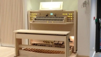 orgel van licht hout in een lichte ruimte met bankje en twee lagen toetsen en enkele registers