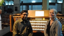Een man en blonde vrouw voor een orgel met vier lagen toetsen en veel registers