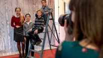 kinderen die gefotografeerd worden op een trap en een vrouw die de foto maakt