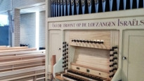 wit orgel met orgelpijpen in een lichte kerk met tekst erop